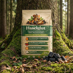 Verpackung der Haselglut Grillkohle aus 100 % Nussschalen vor Baumstamm im Wald, nachhaltige Grillkohle ohne Holz